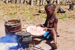 Native Himba boy cooking lunch, Namibia